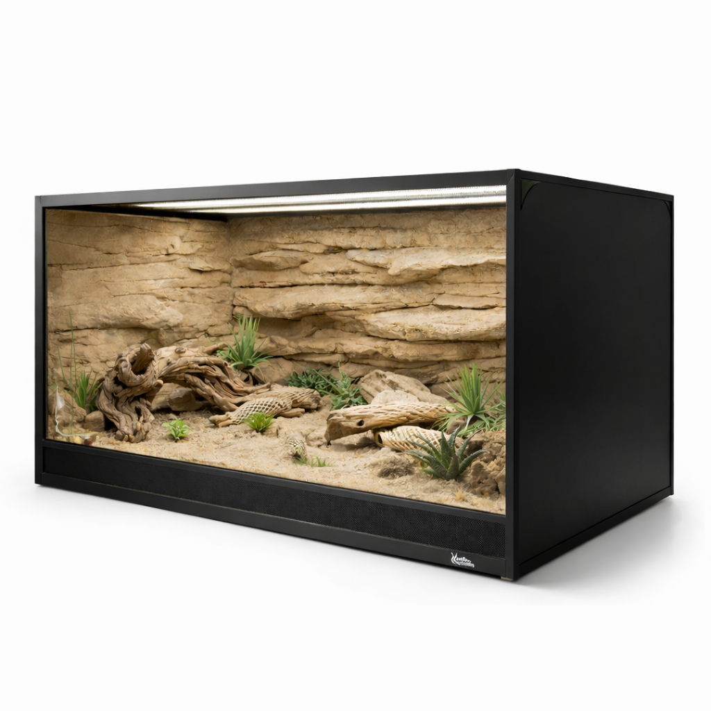 A large black reptile terrarium with a desert-themed interior, featuring sandy substrate, rocks, driftwood, and artificial plants against a textured background.